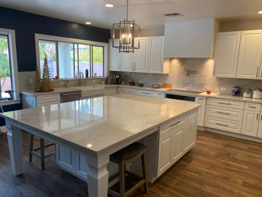 Remodelled kitchen with white cabinetry and a stone countertop
