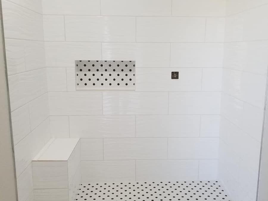 Tiled shower floor with a stone threshold and drain